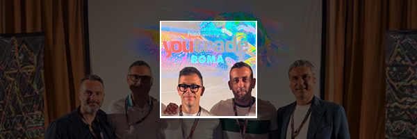 Five men on a stage with a projection screen; a highlighted inset shows three of them posing for a photo.
