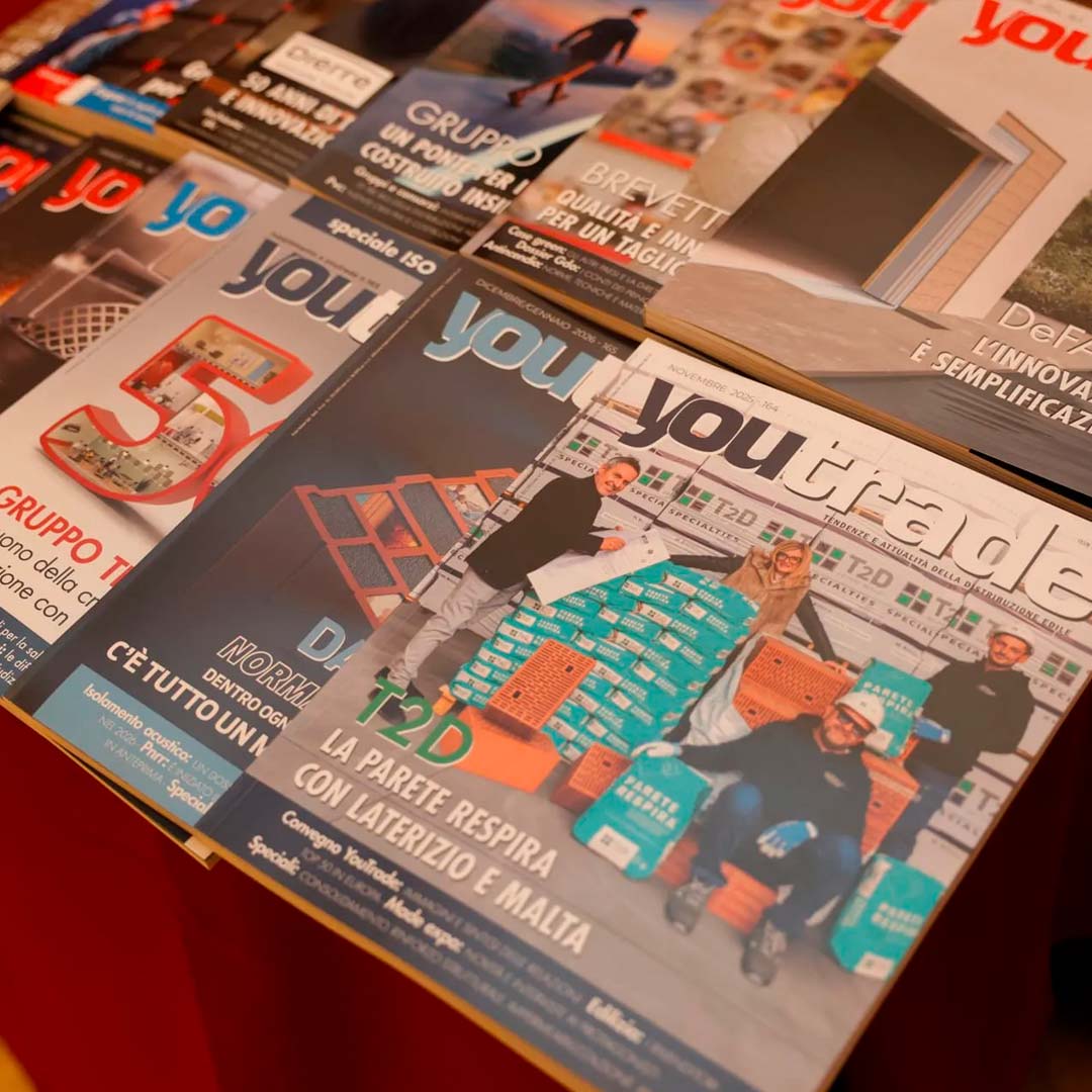 Several issues of a magazine or newspaper titled 'you' spread across a surface, showing a group photo and colorful graphics on the covers.